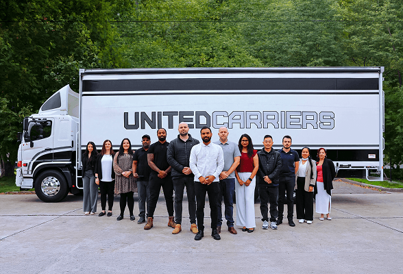 Group of twelve diverse people standing in front of a xxx truck outdoors.