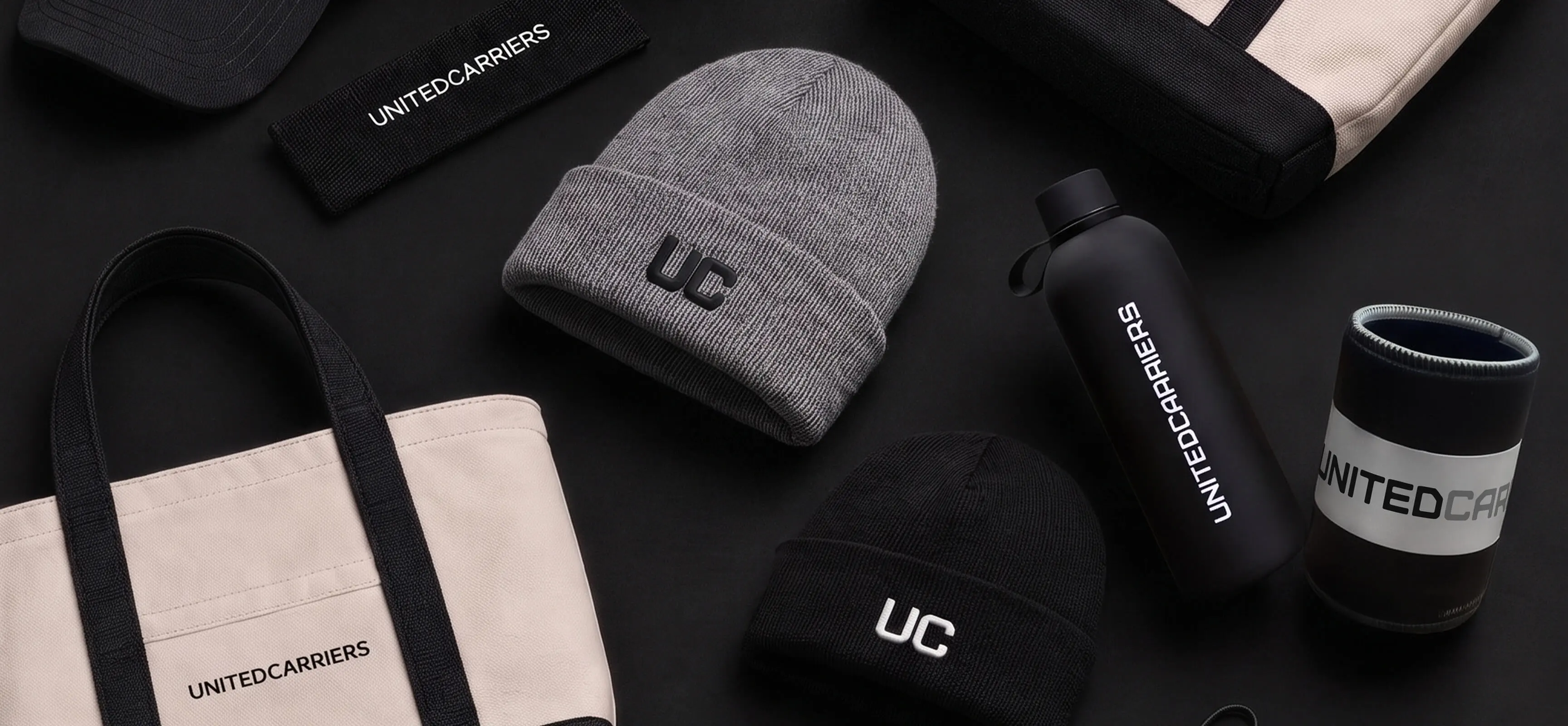 Black and gray beanies, tote bags, water bottle, and sleeve featuring xxx branding.